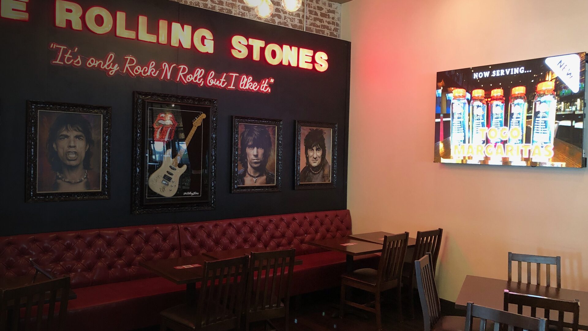 Rolling Stones-themed dining area alongside the LED wall displaying a promotional graphic.